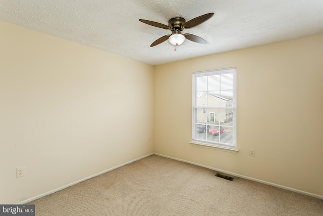 unfurnished room with ceiling fan, light colored carpet, and a textured ceiling