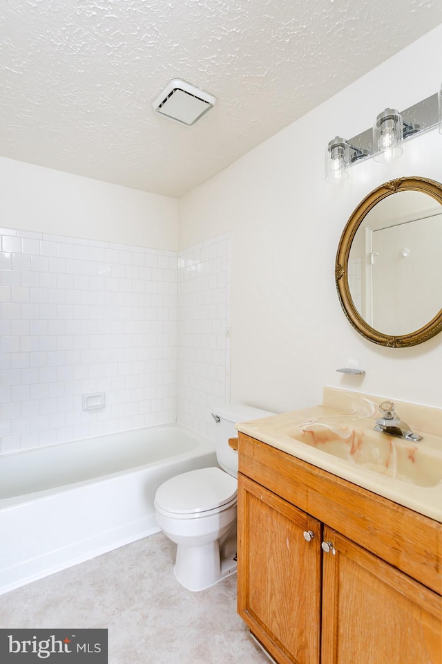 full bathroom featuring vanity, tiled shower / bath, a textured ceiling, and toilet