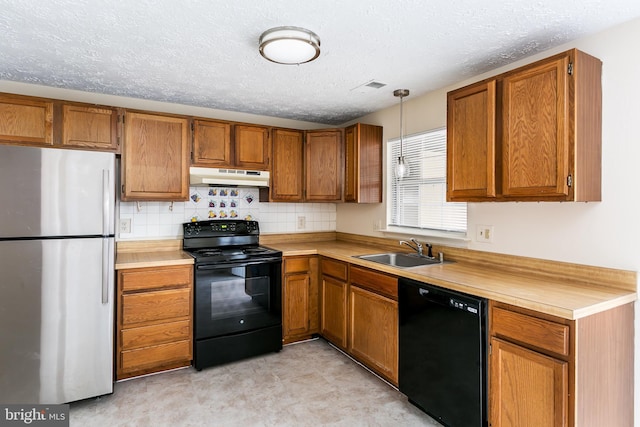 kitchen featuring sink, hanging light fixtures, black appliances, a textured ceiling, and decorative backsplash