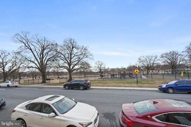 view of car parking featuring a playground