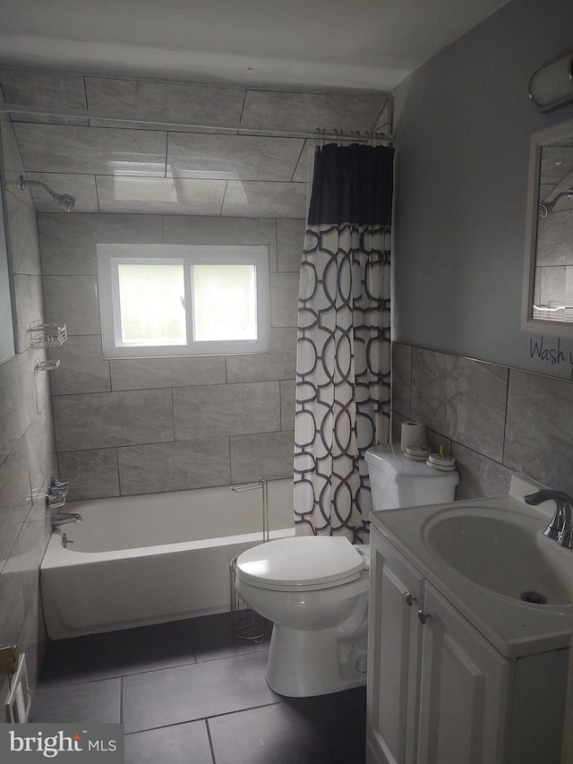 full bathroom featuring tile walls, vanity, toilet, tile patterned floors, and shower / bath combo with shower curtain