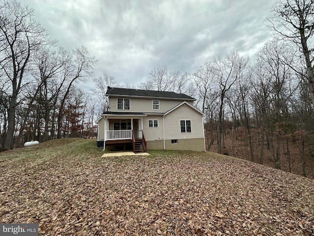 rear view of house featuring covered porch