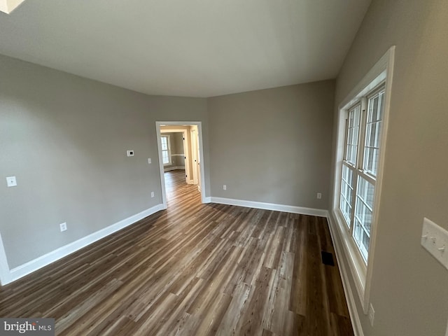 unfurnished room with plenty of natural light and dark hardwood / wood-style flooring