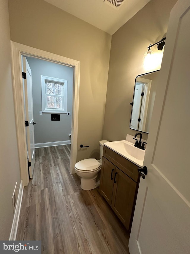 bathroom featuring vanity, hardwood / wood-style floors, and toilet