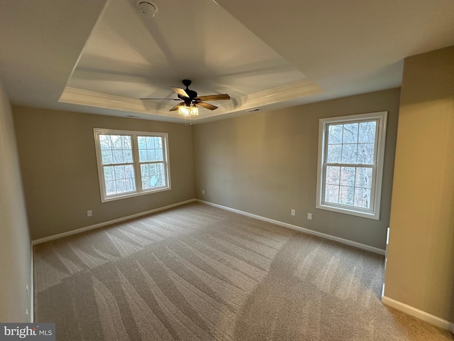 carpeted empty room featuring ceiling fan and a tray ceiling