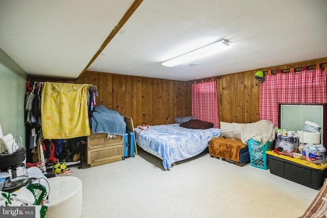 bedroom featuring wood walls