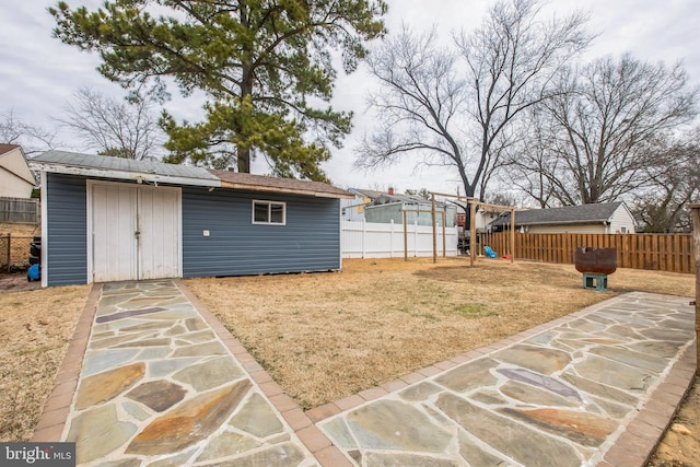 view of yard featuring a storage shed, a patio, and a playground