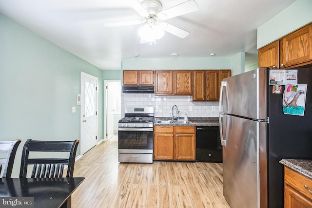 kitchen with sink, decorative backsplash, light hardwood / wood-style flooring, and appliances with stainless steel finishes