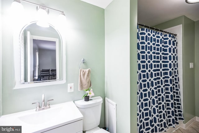 bathroom featuring tile patterned flooring, vanity, toilet, and walk in shower