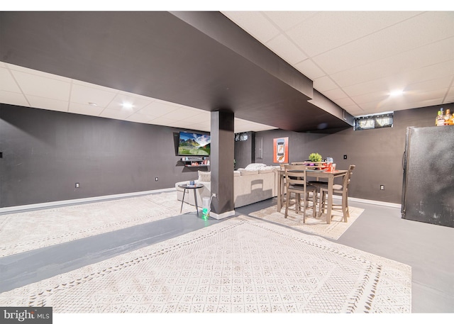 dining space with a paneled ceiling and concrete floors