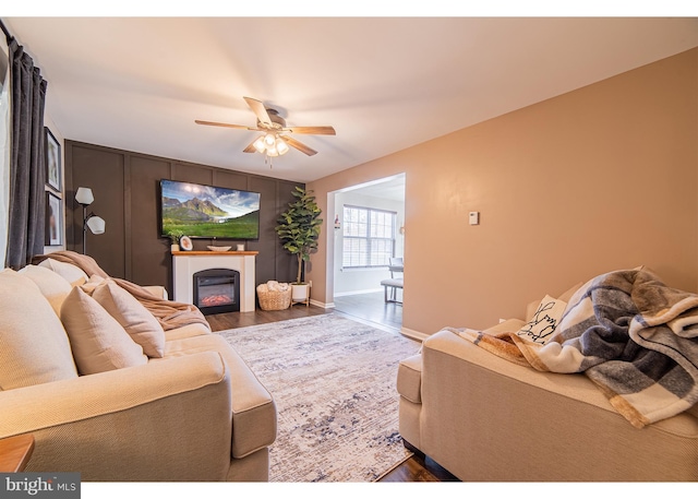 living room with dark wood-type flooring and ceiling fan