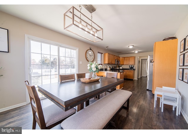 dining space with dark hardwood / wood-style floors, sink, and a chandelier