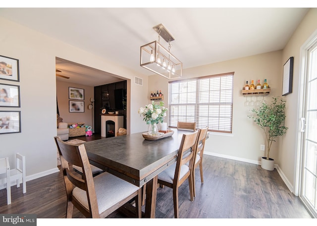 dining area featuring dark wood-type flooring and a notable chandelier