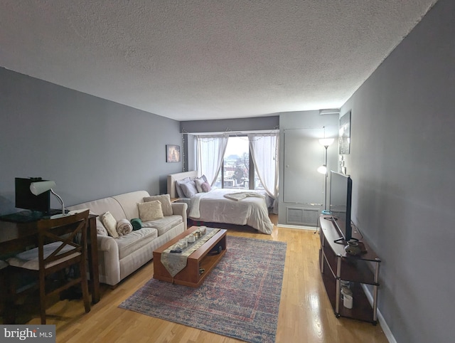 bedroom with a textured ceiling and light wood-type flooring