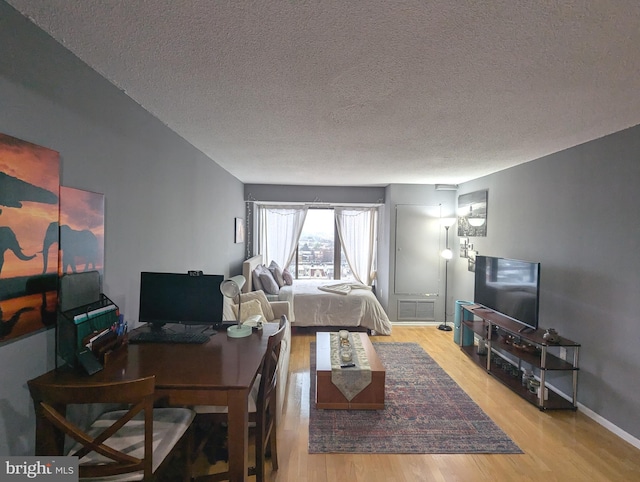 living room with a textured ceiling and light wood-type flooring