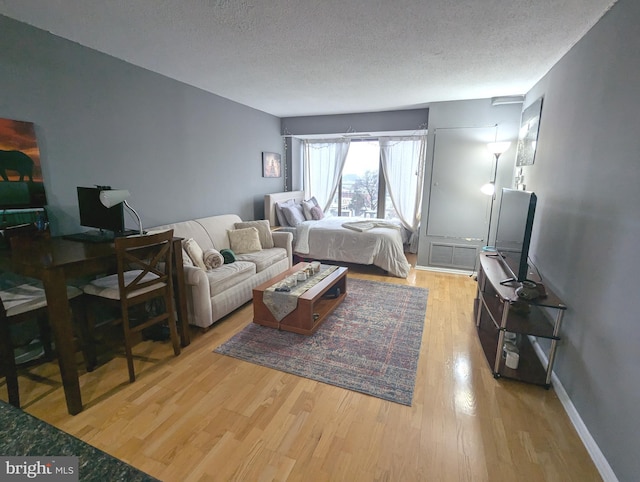 bedroom with light hardwood / wood-style flooring and a textured ceiling