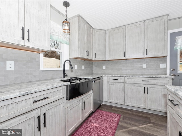 kitchen with light stone counters, pendant lighting, backsplash, dark wood-type flooring, and dishwasher