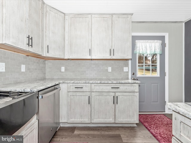 kitchen featuring light stone counters, backsplash, stainless steel dishwasher, and wood finished floors