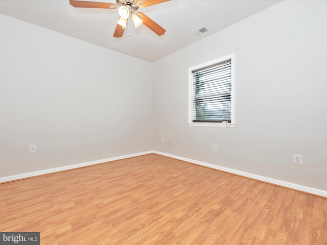 empty room with light wood-style floors, baseboards, visible vents, and a ceiling fan