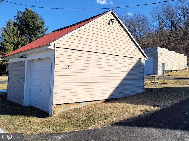 view of home's exterior with a garage, metal roof, and an outdoor structure