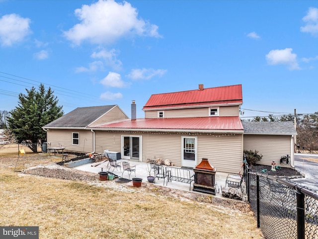 back of house with a chimney, fence, a lawn, and a patio