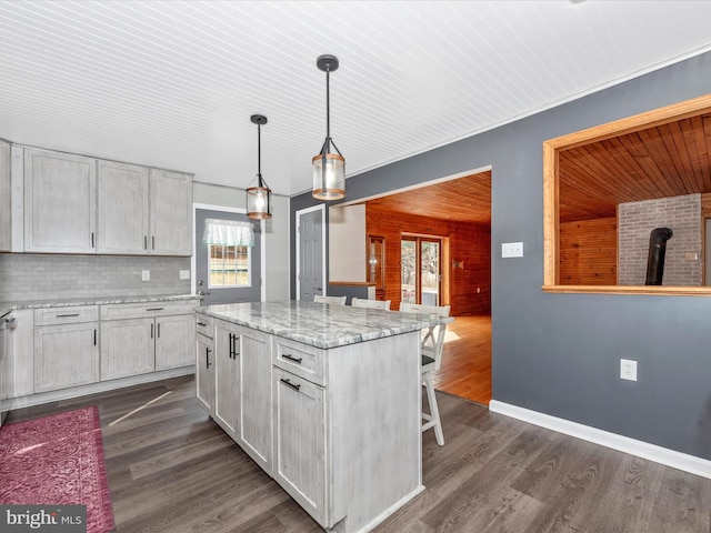 kitchen with dark wood-style floors, a center island, white cabinets, and decorative light fixtures