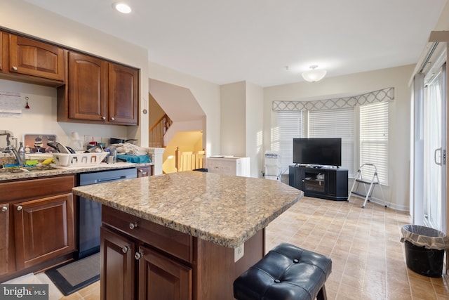 kitchen with light stone counters, a center island, recessed lighting, a sink, and dishwasher