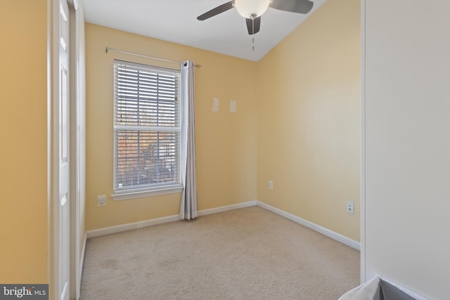 spare room with light carpet, a ceiling fan, and baseboards