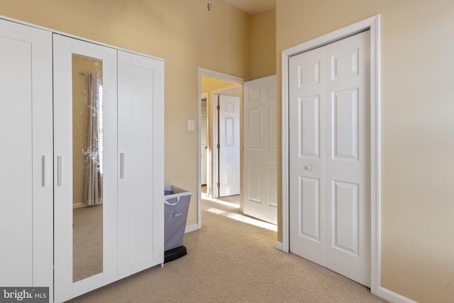 hall featuring light carpet and baseboards