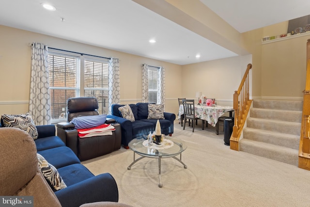 living area with recessed lighting, light colored carpet, and stairs