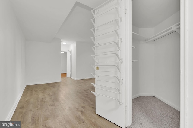 walk in closet with light hardwood / wood-style flooring