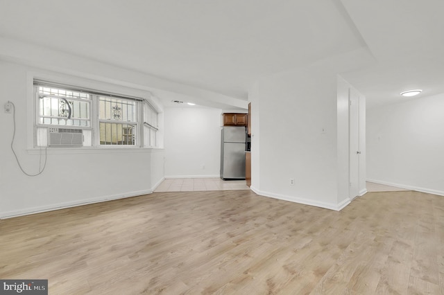 unfurnished living room with cooling unit and light hardwood / wood-style floors