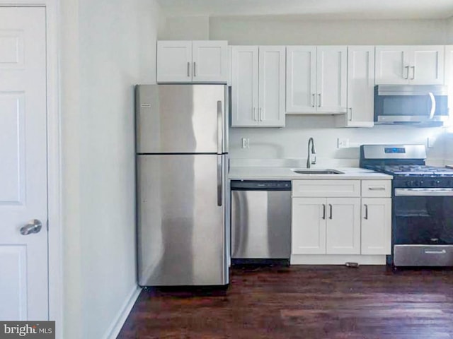 kitchen featuring white cabinetry, appliances with stainless steel finishes, sink, and dark wood-type flooring