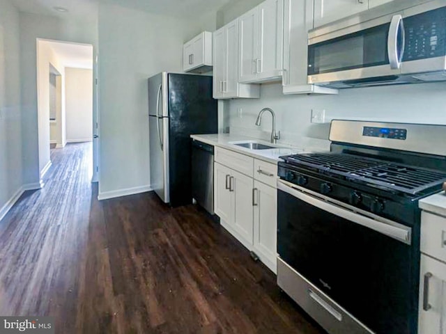 kitchen featuring dark wood-type flooring, stainless steel appliances, sink, and white cabinets