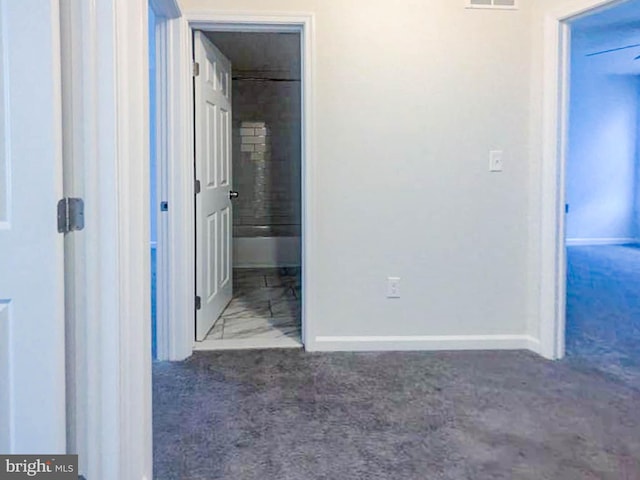 unfurnished bedroom featuring dark colored carpet and ensuite bath