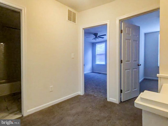 hallway featuring dark carpet