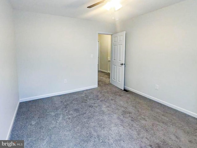 unfurnished room featuring dark carpet and ceiling fan