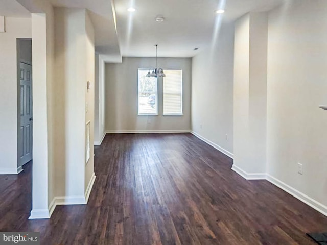 unfurnished dining area with dark hardwood / wood-style floors and a chandelier