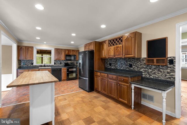 kitchen featuring butcher block countertops, black appliances, ornamental molding, visible vents, and recessed lighting