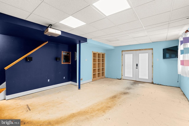 interior space with a paneled ceiling, baseboards, and french doors
