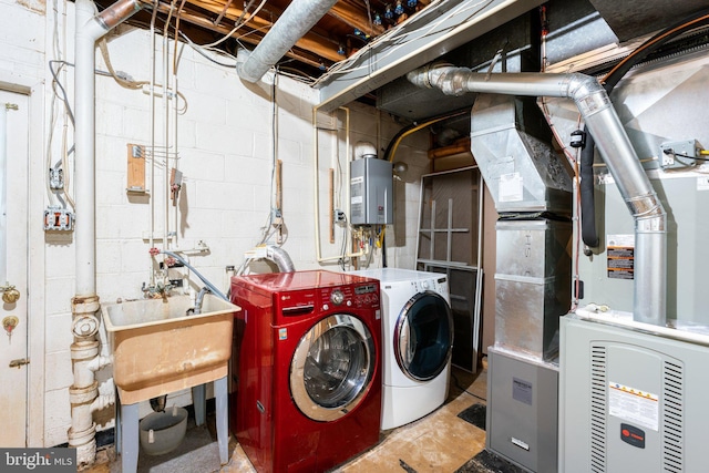 laundry area with tankless water heater, independent washer and dryer, and laundry area
