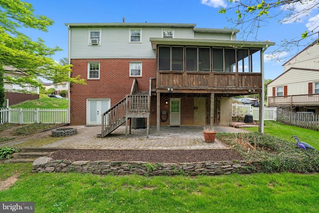 rear view of property featuring a fire pit, a sunroom, a patio area, and a fenced backyard
