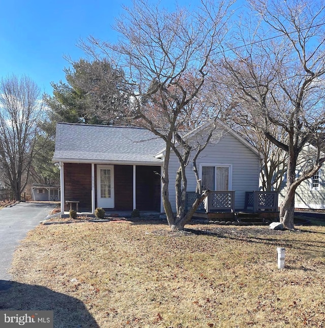 single story home featuring a garage, an outdoor structure, and a front lawn