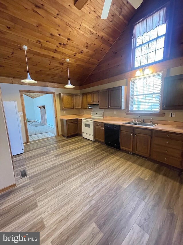 kitchen featuring high vaulted ceiling, sink, hanging light fixtures, white appliances, and light hardwood / wood-style flooring