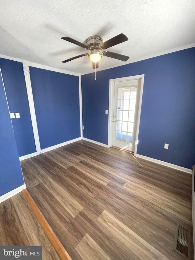 unfurnished room featuring ceiling fan, dark wood-type flooring, and a textured ceiling