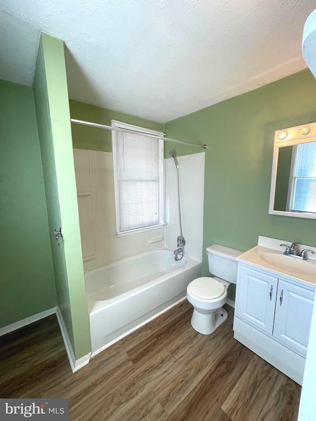 full bathroom featuring toilet, bathtub / shower combination, a textured ceiling, vanity, and hardwood / wood-style floors