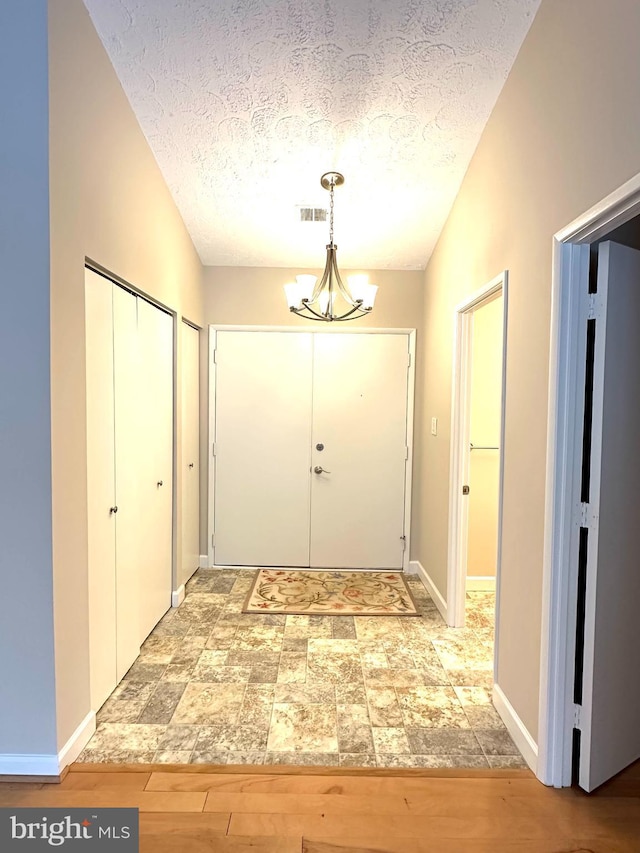 interior space featuring a notable chandelier, hardwood / wood-style floors, and a textured ceiling