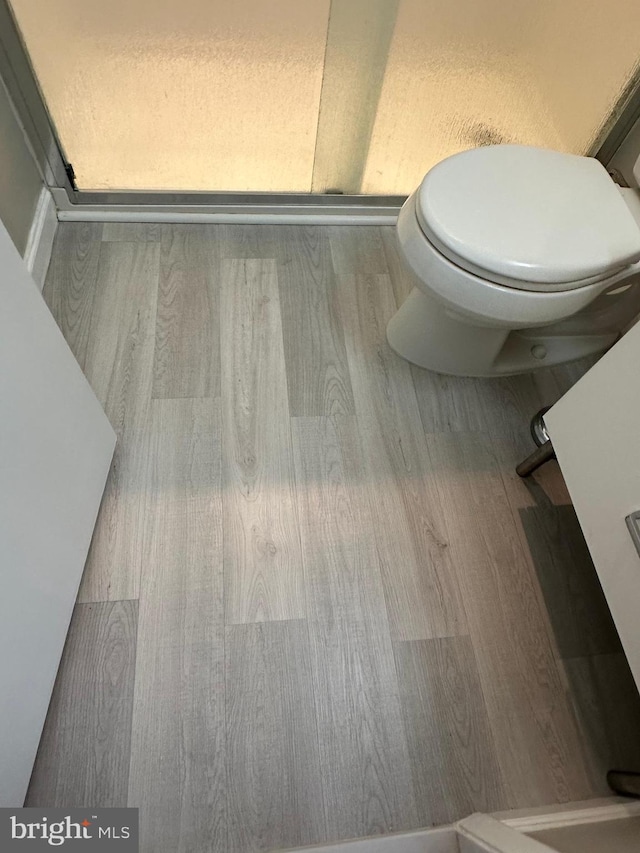 bathroom with hardwood / wood-style flooring and toilet