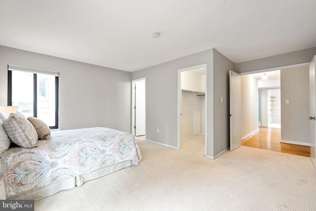 carpeted bedroom featuring a walk in closet and a closet