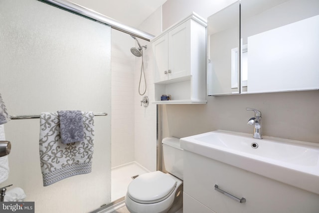 bathroom featuring tiled shower, toilet, and sink